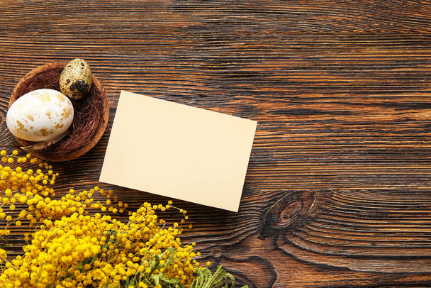 Hermosa composición de Pascua con tarjeta en blanco, huevos y flores sobre fondo de madera - Foto, Imagen