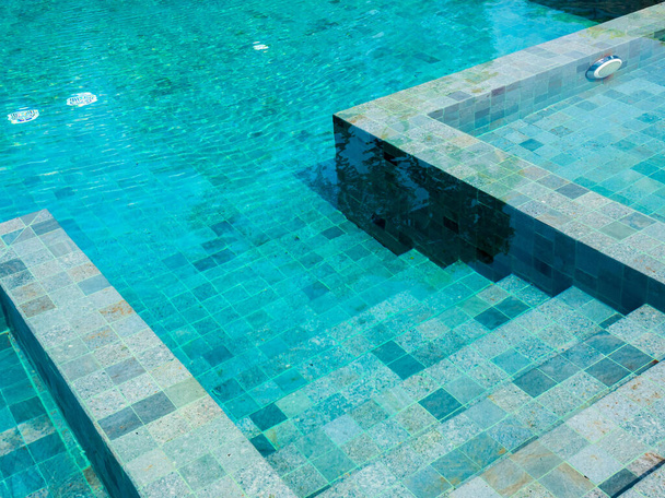 Schody do bazénu s čistou vodní hladinou, nikdo. Abstraktní struktura bazénu, podvodní vzor modré pozadí s mřížkou dlaždice, bez lidí. Pohled shora. Letní pozadí. - Fotografie, Obrázek