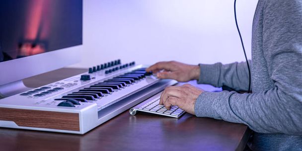 Férfi zenész zenét hoz létre a számítógép és billentyűzet, zenész munkahely. - Fotó, kép