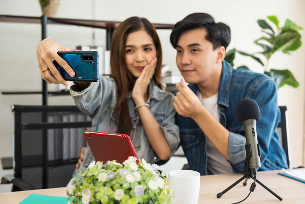Słodka para selfie i pokazać mini gest serca, aby świętować Walentynki. Młody azjatycki vlogger influencers nagrywać wideo online streaming na żywo i nadawanie w sieciach społecznościowych. - Zdjęcie, obraz