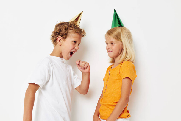 cheerful children with caps on his head holiday entertainment isolated background unaltered - 写真・画像