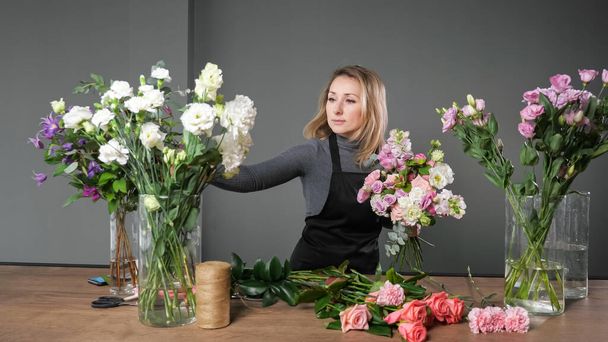 Florista mujer compone elegante ramo con flores de colores - Foto, Imagen