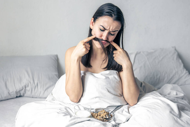 Una joven en cama blanca con cereales y leche. - Foto, Imagen
