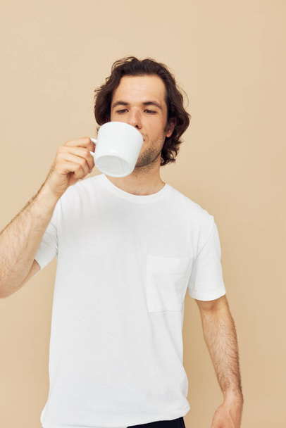 Cheerful man with a white mug in his hands emotions posing isolated background - Foto, Bild