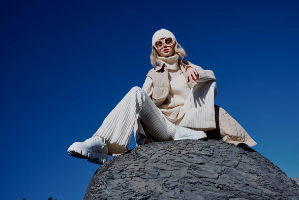 žena sedí na kamenné přírodě modrá obloha v klobouku relaxace - Fotografie, Obrázek