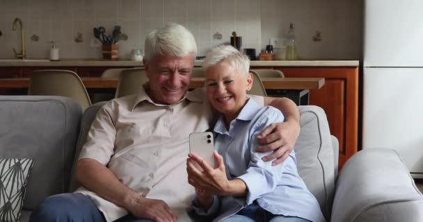 Older couple have fun using modern smart phone - Кадры, видео