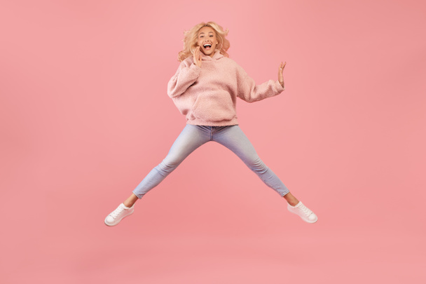 Wow offer. Full length portrait of surprised lady jumping, staring at camera, shocked by news or offer, pink background - Foto, Imagem