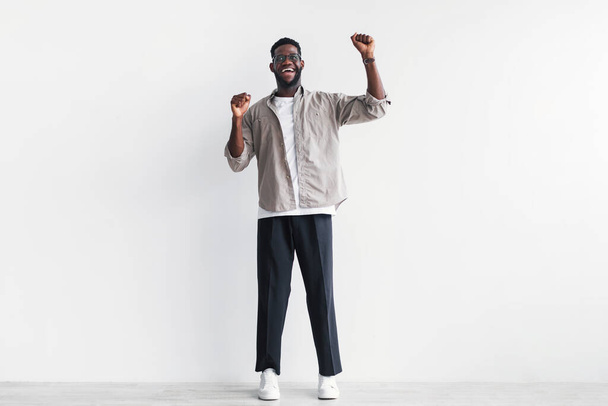 Overjoyed young black man screaming in excitement, gesturing YES with both hands against white studio wall, copy space - Foto, Bild