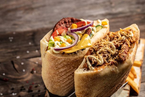 sluiting van kebab sandwich op houten ondergrond. Turkse kip doner sandwich. fast food en junk food concept, Straat voedsel. - Foto, afbeelding