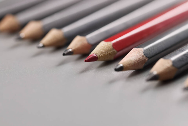 Bleistiftspitzen streng geordnet auf graue Oberfläche legen, rote unter schwarze Stifte - Foto, Bild