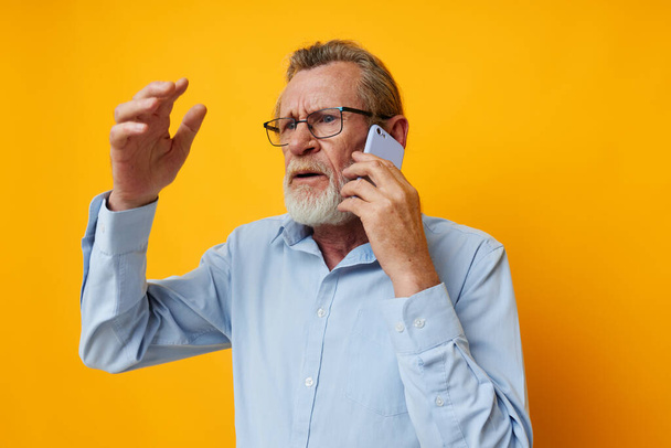 Portrait elderly man talking on the phone posing close-up isolated background - Foto, Imagen