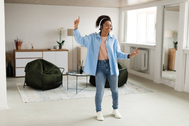 Μαύρη κυρία που ακούει μουσική και χορεύει στο σπίτι - Φωτογραφία, εικόνα