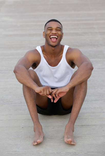 Young man smiling outdoors barefoot and in shorts - Fotoğraf, Görsel