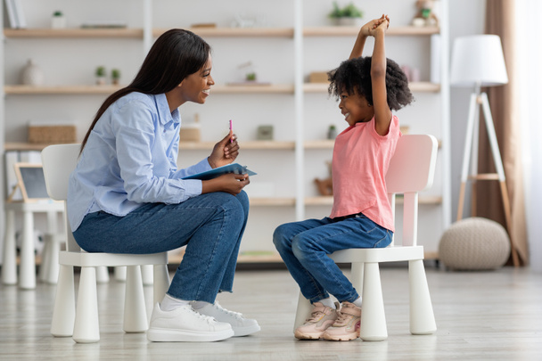 Захватывающая маленькая черная девочка в офисе детского психолога - Фото, изображение