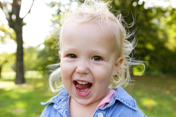 Cute little girl laughing outdoors - Foto, Imagen