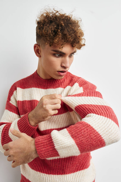 handsome young man in a striped sweater posing isolated background - Zdjęcie, obraz