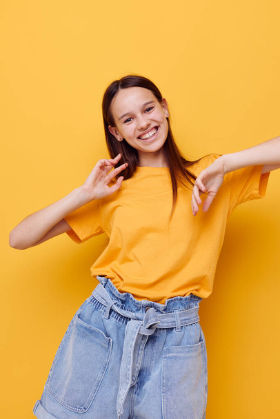 young beautiful woman fashion in yellow t-shirt denim shorts isolated background - Fotó, kép