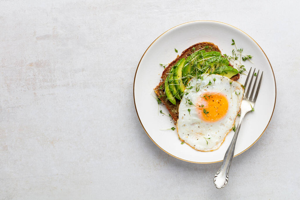 Keto colazione uova fritte, avocado e pane in un piatto bianco. Keto concetto di dieta. - Foto, immagini