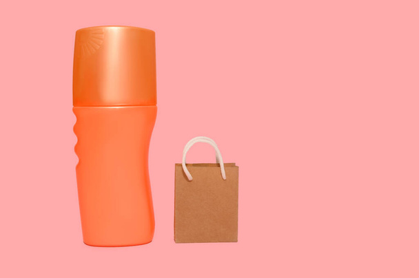 Orange plastic container. Shopping bag. On a pink background. - Φωτογραφία, εικόνα