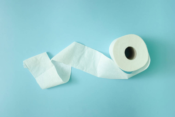 White toilet paper roll on light pastel blue background. Copy space, flat lay. - Photo, Image