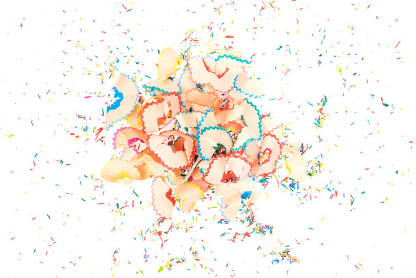 Bouquet de copeaux de crayon colorés avec des miettes de graphite colorées isolées sur un fond blanc. gros plan - Photo, image