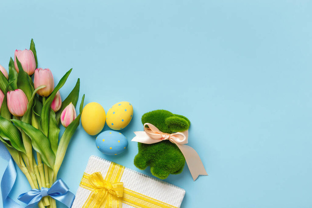Tulips spring flowers easter eggs gift bunny on a blue background. Top view flat lay copy space. - Fotografie, Obrázek