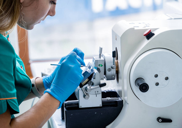 Laboratory assistant works on a rotary microtome section and making microscope slides - Foto, afbeelding