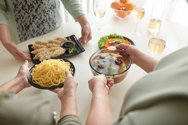 テーブルに食べ物を置く女性の友人 - 写真・画像