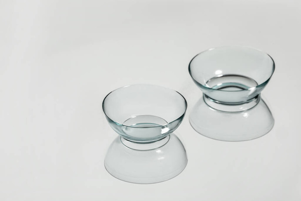 Pair of contact lenses on white reflective surface - Foto, imagen