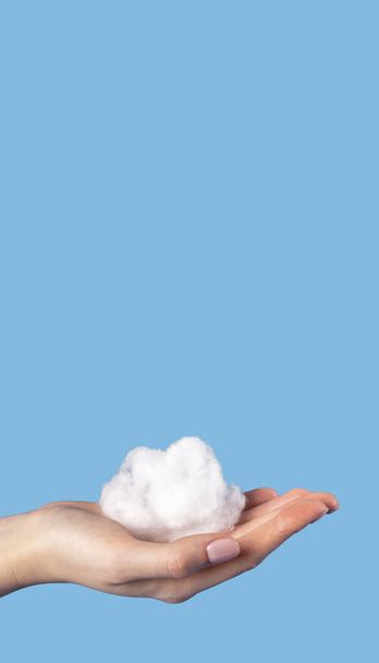 Banner with hand holding cloud at blue sky background. Cotton wool in surrealism style. Copyspace  - Fotografie, Obrázek