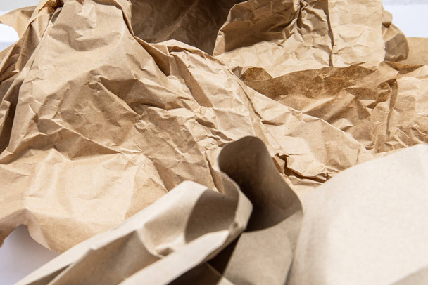Papel castanho amassado sobre um fundo branco. Reciclagem de papel artesanal - Foto, Imagem