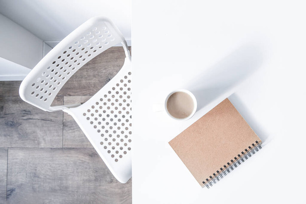 Witte kop koffie, een notitieboekje op een witte tafel, ernaast staat een stoel. Bovenaanzicht, vlak lay - Foto, afbeelding