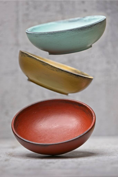 A conceptual studio photo of three bowls being dropped. - Photo, Image