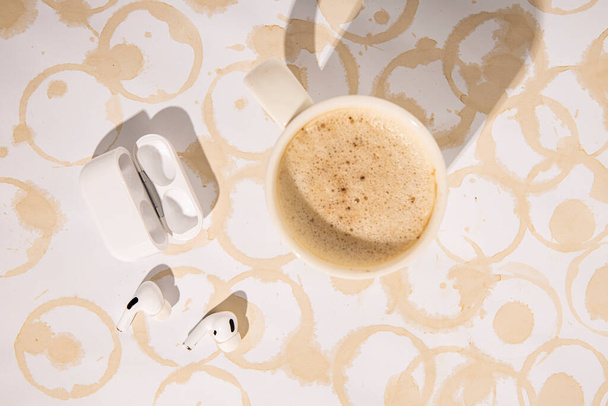 Mesa con rastros de tazas de café. Café, auriculares. Piso tendido, vista superior - Foto, imagen