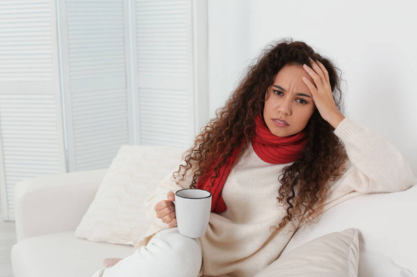 Sick African American woman with cup of hot drink at home - Photo, Image