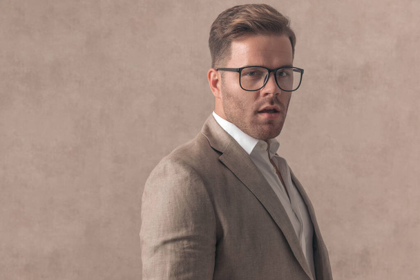 portrait de jeune homme d'affaires avec des lunettes posant sur fond ebige en studio, confiant et cool - Photo, image
