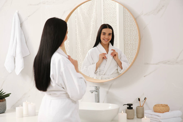Beautiful young woman near mirror in bathroom - Fotoğraf, Görsel