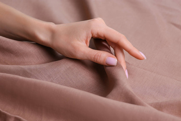 Woman touching soft light brown fabric, closeup - Foto, Imagen