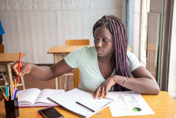 Αφρικανίδα μαθήτρια λυκείου που κάνει εξετάσεις στην τάξη - Φωτογραφία, εικόνα