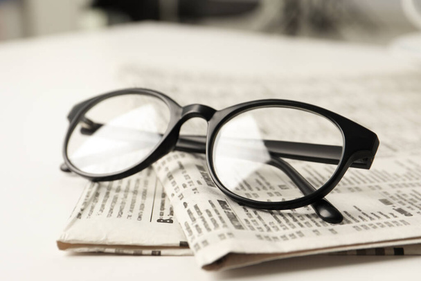Newspapers and glasses on white table, closeup - Foto, Bild