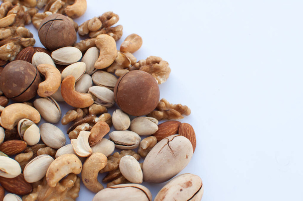 a variety of nuts scattered on a white background with space for text - Photo, Image