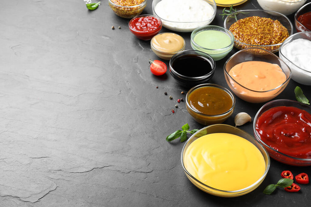 Many different sauces on black table, space for text - Foto, Imagen