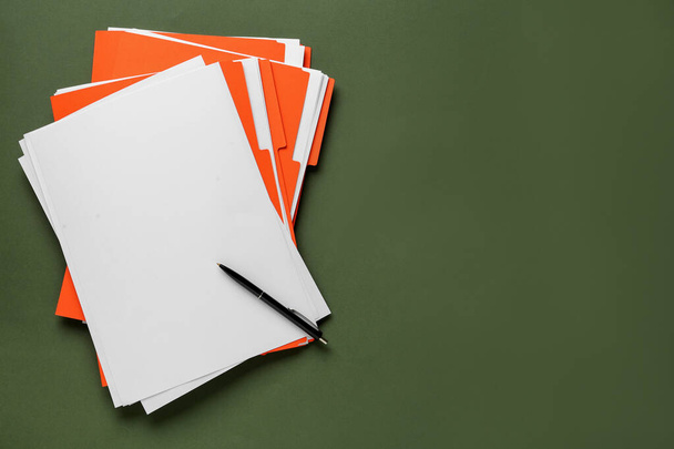 Orange files with blank sheets of paper and pen on dark green background, top view. Space for text - Fotografie, Obrázek