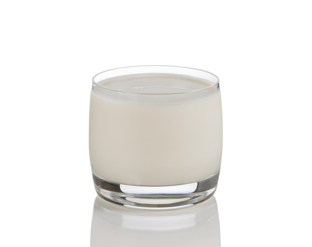 γεμάτο ποτήρι φρέσκο γάλα σε λευκό με αντανάκλαση  - Φωτογραφία, εικόνα