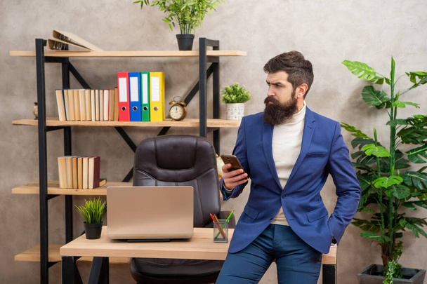 Simple way to connect. Serious man using smartphone at work. Smartphone communication. SMS messaging - Fotó, kép