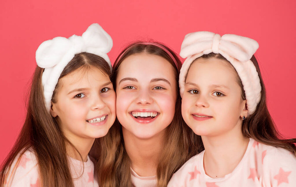 Portrait of happy kids with smiling faces in homewear pink background - Foto, imagen