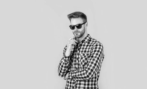 young handsome guy in checkered shirt and glasses. stylish male wear casual clothes. bearded man with bristle on unshaven face. fashion and beauty. barbershop concept. mens wear. Loving new style - Foto, Imagem
