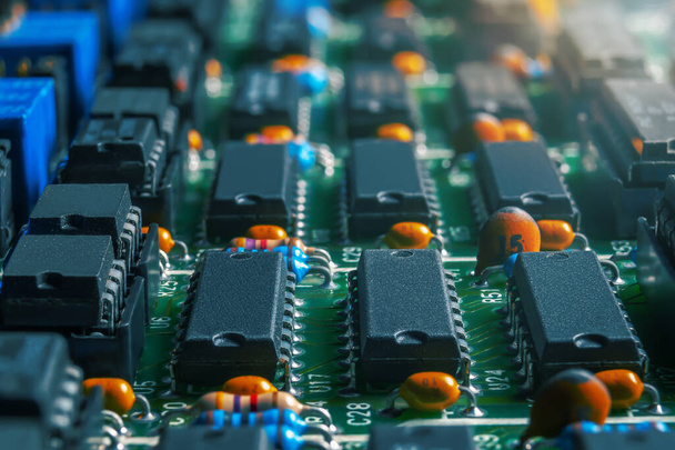 Primer plano de la placa de circuito impreso con circuitos integrados y muchos otros componentes eléctricos pasivos. - Foto, Imagen