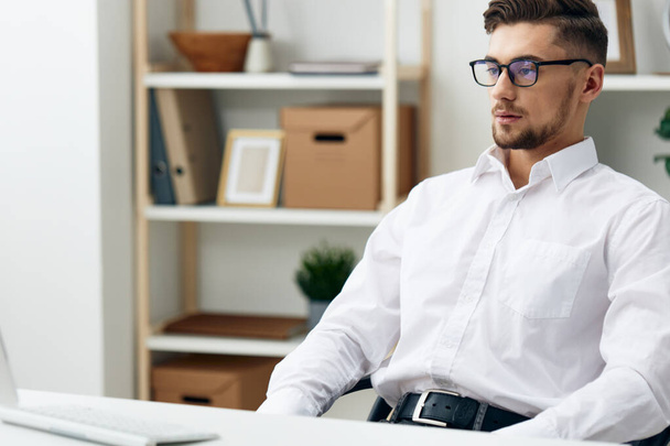 gestionnaire portant des lunettes est assis à un bureau de bureau a travaillé bureau - Photo, image