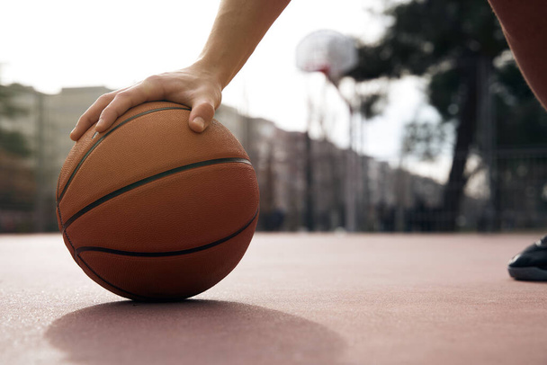 jugador que sostiene el baloncesto en la cancha - Foto, Imagen